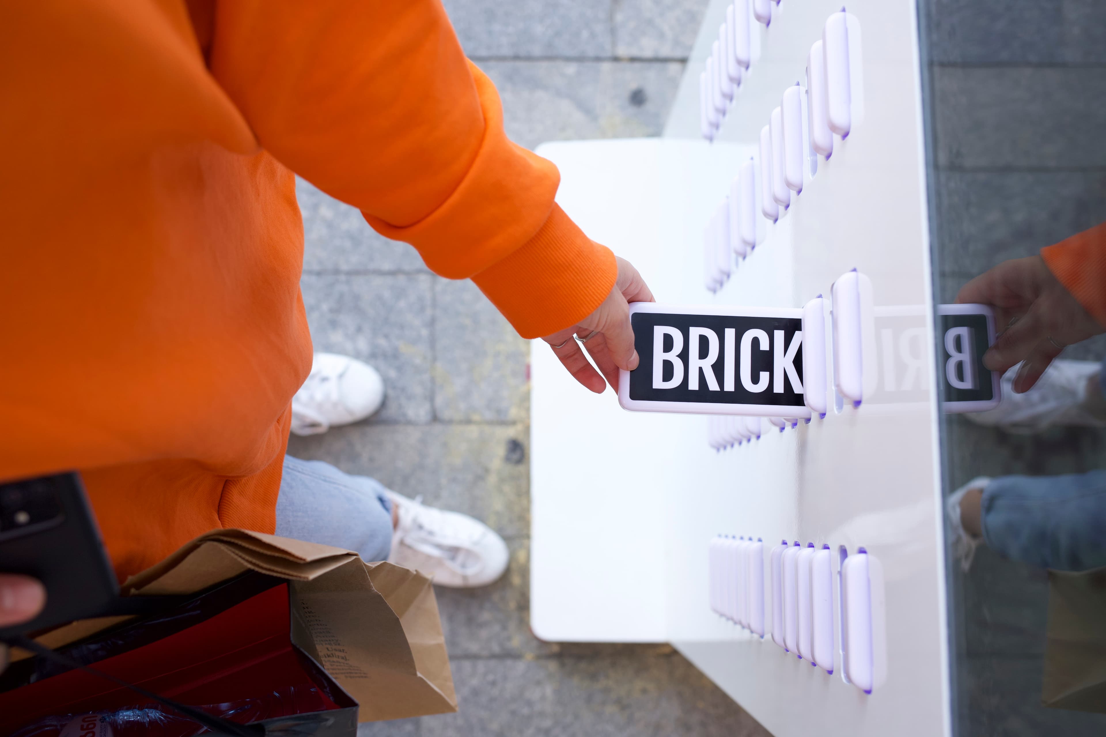 Eine Hand holt eine Brick-Powerbank aus einer Station